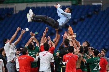Los jugadores de México lanzan al aire al entrenador Jaime Lozano. (VINCENZO PINTO / AFP)