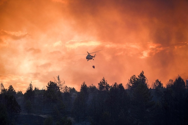 Un helicóptero participa en las labores de extinción de un incendio en el pueblo de Machevo, a unos 180 km de Skopie, la capital de Macedonia del Norte, el pasado 6 de agosto. (Arbnora MEMETI | AFP)