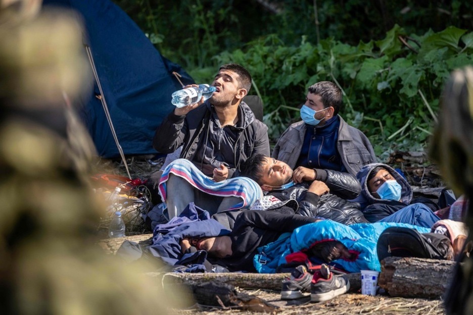 Los migrantes descansan en el campamento improvisado en Usnarz Gorny.  (Wojtek RADWANSKI | AFP)