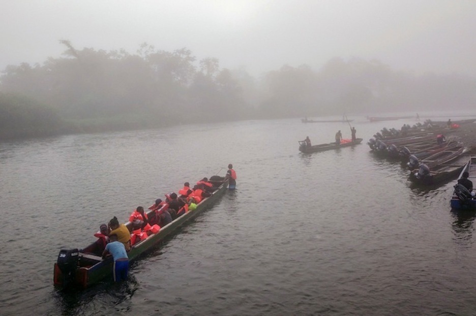 Las canoas transportando a los migrantes hacia Lajas Blancas se adentran en la niebla. (Ivan PISARENKO | AFP) Las canoas transportando a los migrantes hacia Lajas Blancas se adentran en la niebla. (Ivan PISARENKO | AFP)