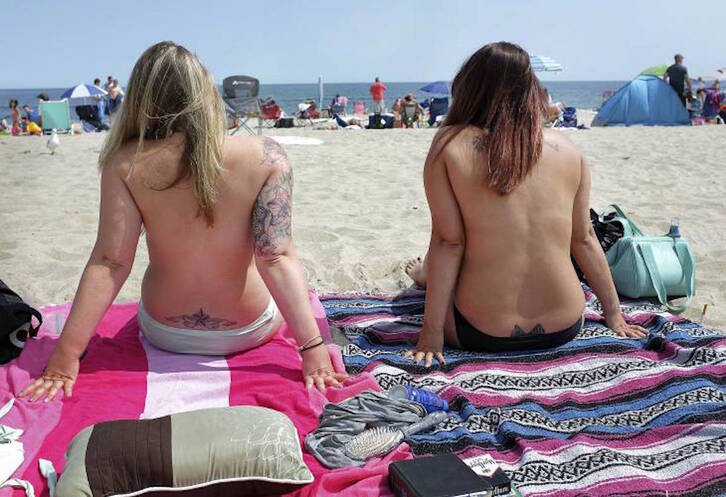 Dos mujeres participan en un acto en favor del topless en Hampton Beach. (AP)
