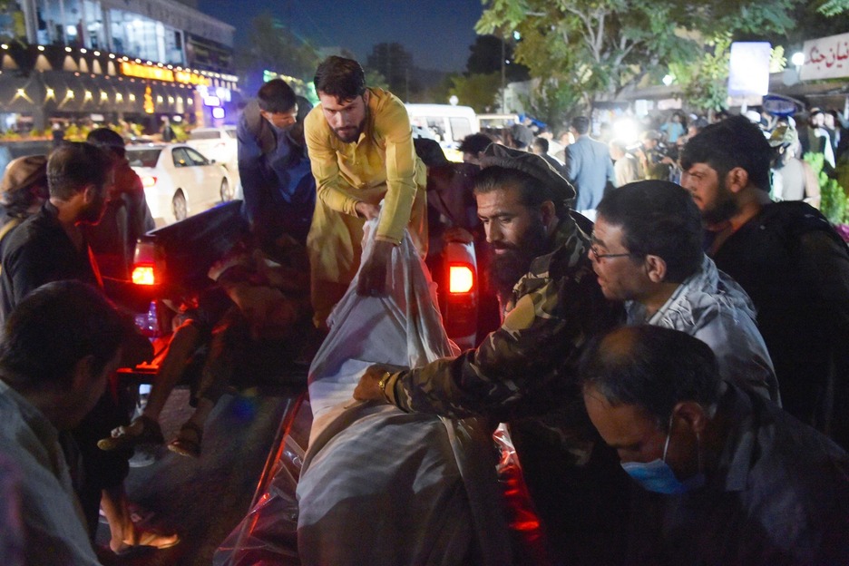 Voluntarios y personal médico descargan cuerpos de una camioneta fuera de un hospital. (Wakil KOHSAR/AFP) Voluntarios y personal médico descargan cuerpos de una camioneta fuera de un hospital. (Wakil KOHSAR/AFP)