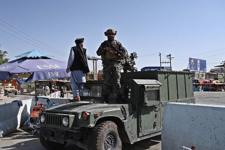 Un soldado de la unidad de élite Badri 313, las fuerzas especiales de los talibanes, monta guardia sobre un vehículo Humvee en la entrada principal del Aeropuerto de Kabul. (Wakil KOHSAR/AFP)