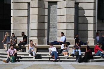 Trabajadores de oficinas almuerzan al aire libre en Londres, el 6 de setiembre, aprovechando el clima veraniego. (Daniel LEAL-OLIVAS/AFP)