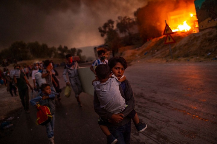 Una de las impactantes imágenes tomadas el 9 de septiembre de 2020 mientras los refugiados huían de las llamas en el campamento de Moria, en la isla de Lesbos. (Angelos TZORTZINIS/AFP)