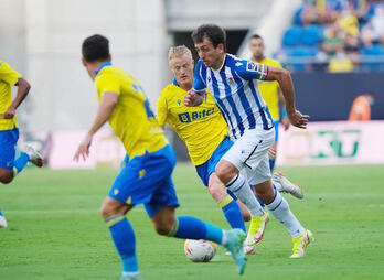 Oyarzabal conduce el balón ante la mirada del pivote gaditano Jonsson. (Agencia LOF) 