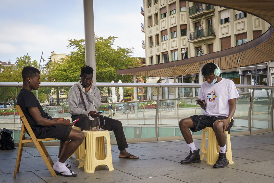 Migrante talde bat, bilera ostean Afrikan utzi eta Europan zain dituzten beraien senide eta lagunekin mugikorren bidez komunikatzen. (Gorka RUBIO | FOKU)