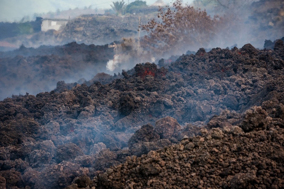 La lava, todavía incandescendente, se va solidificando rodeada de humo. (Arturo JIMÉNEZ/EUROPA PRESS)