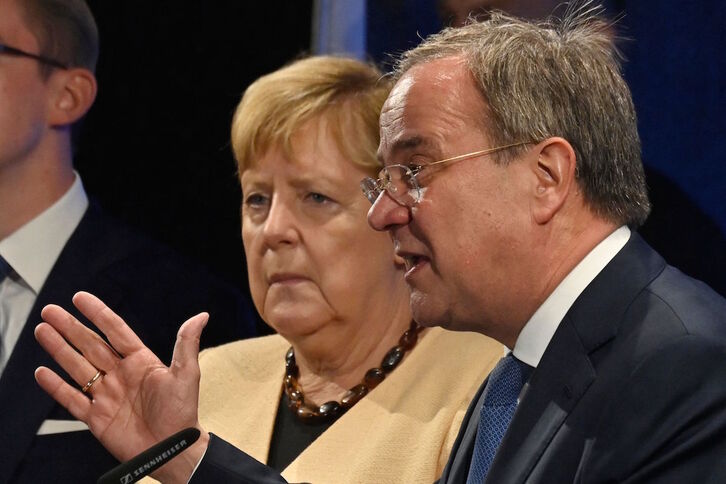 La canciller Angela Merkel observa a Armin Laschet, candidato a sucederla por su partido, la CDU, en un acto de campaña en Stralsund. (John MACDOUGALL / AFP)
