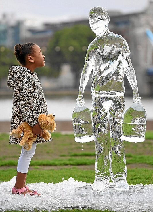 Ume bat uraren erabileraren hauskortasuna erakusten duen eskultura bati begira, Londresen. (Daniel LEAL OLIVAS I AFP)