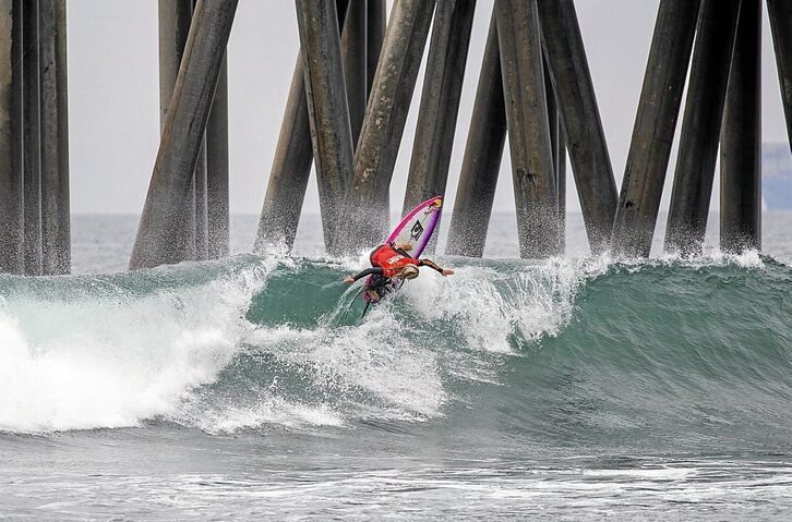 Caitlin Simmers, bizkarkako bira bat egiten Huntington hondartzako nasako zutoinen ondoan. (WORLDSURFLEAGUE.COM)