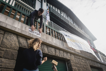 Ekintzaileak, etxe huts batean afixak jartzen. (Guillaume FAUVEAU)