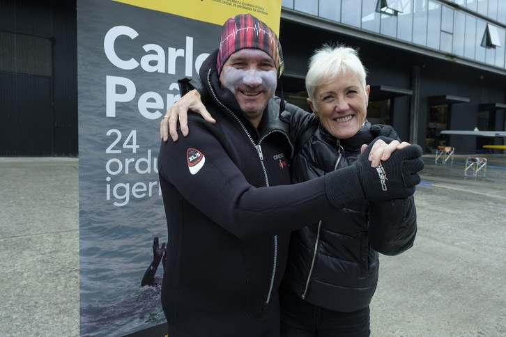 El nadador Carlos Peña junto con la presidenta del Colegio de Enfermeras de Gipuzkoa (COEGI) Pilar Lekuona, antes del inicio de la travesía de 24 horas de nado ininterrumpido de Peña, en Orio. (Jon URBE/FOKU)