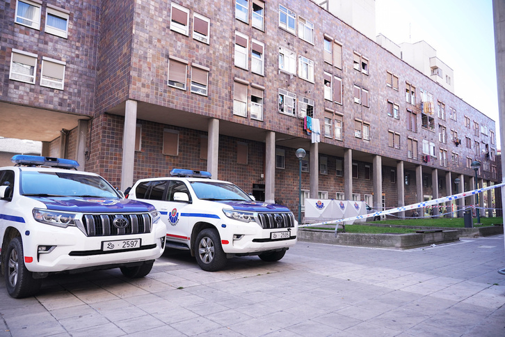 Vehículos de la Ertzaintza ante el bloque de pisos en el que ha ocurrido el crimen. (Endika PORTILLO / FOKU)