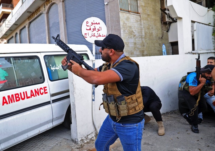 Un miliciano de Amal se parapeta tras una ambulancia. (ANWAR AMRO/AFP)