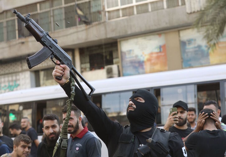 Un miembro de Hizbulah dispara su arma durante los funerales. (Ibrahim AMRO/AFP)