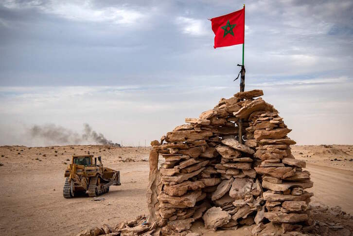 Una excavadora pasa junto a un puesto levantado por el Ejército marroquí en la zona de Guerguerat. (Fadel SENNA/AFP)