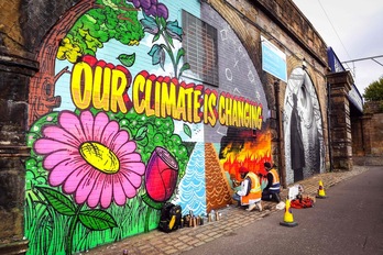 Artistas callejeros pintan un mural frente a la sede de la COP26 en Glasgow (Escocia). (Andy BUCHANAN/AFP) 
