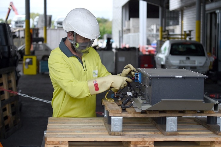 Un trabajador manipula la batería de un vehículo eléctrico Citroën Ami en la planta de reciclaje de Indra en la localidad francesa de Romorantin. (Eric PIERMONT/AFP) 