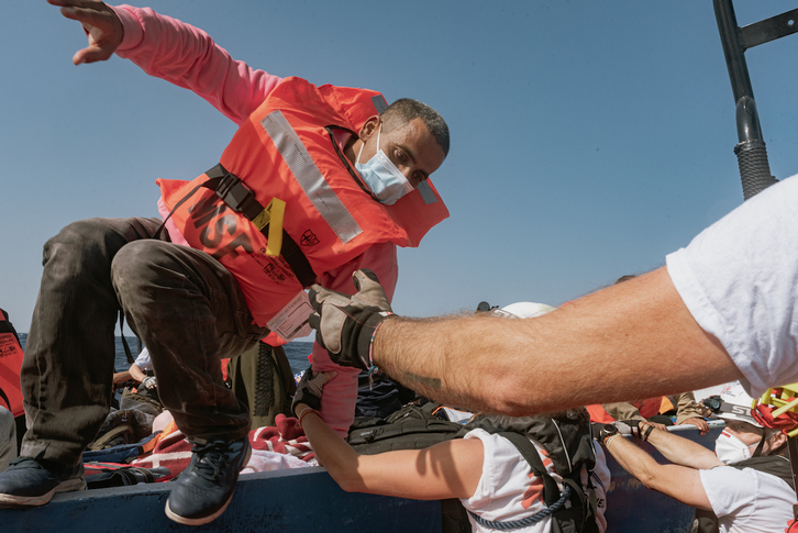 Un migrante es trasladado desde un bote de madera al barco de búsqueda y rescate humanitario Geo Barents de MSF el pasado día 22. Las otras fotos que acompañan la información corresponden a los rescates realizados el fin de semana. (Filippo TADDEI / MSF)