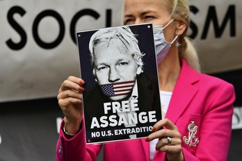 Una manifestante porta un cartel para exigir la libertad de Assange. (Justin TALLIS/AFP)