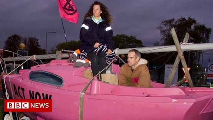 Los deportistas Laura Baldwin y Etiene Stott –medallista en Londres 2012– forman parte del grupo que se ha encandenado en las instalacciones de Exxon Mobil, como se observa en esta imagen televisiva de la BBC.