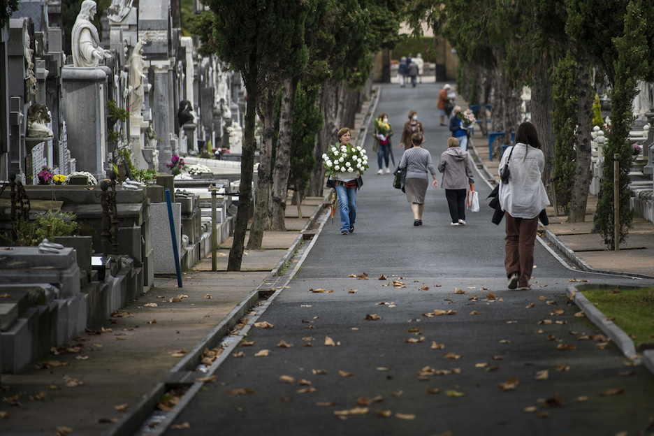 Diferentes personas dejan flores a sus seres queridos en el cementerio Polloe de Donostia. (Gorka RUBIO/FOKU)