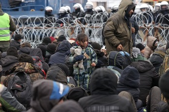 Refugiados se agolpan en la frontera frente a los policías polacos. (OKSANA MANCHUK-AFP)