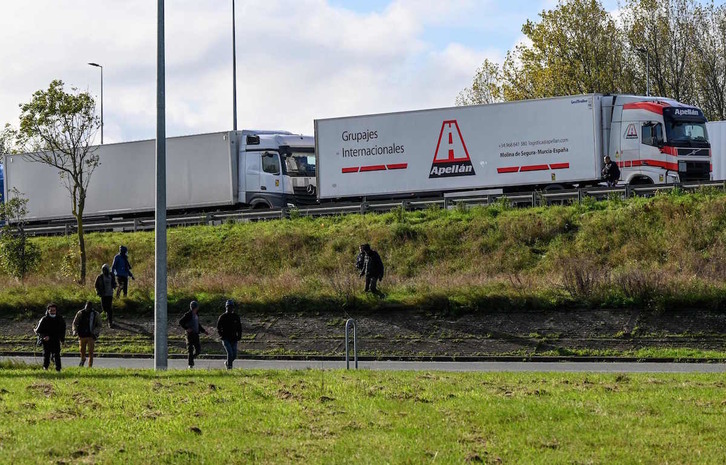 Un grupo de migrantes camina junto a la autopista en las inmediaciones de Calais. (Denis CHARLET/AFP)