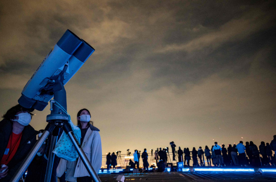 La gente observa el fenómeno lunar con telescopios en Tokio. (Philip FONG / AFP) La gente observa el fenómeno lunar con telescopios en Tokio. (Philip FONG / AFP)