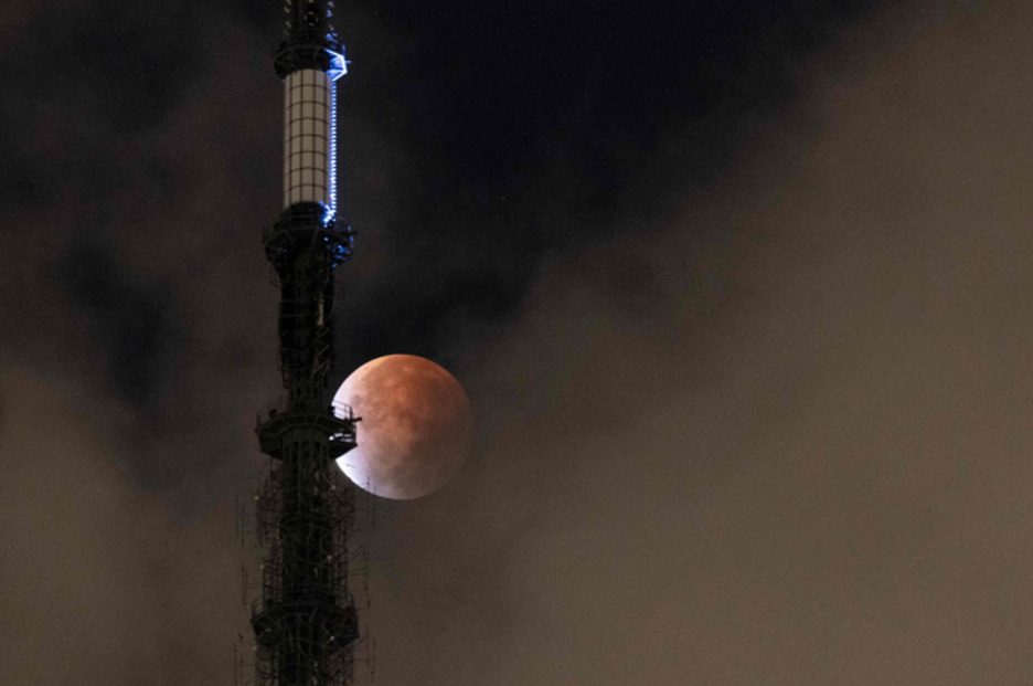 La luna asoma destrás del One World Trade Center de Nueva York. (Yuku IWAMURA / AFP)