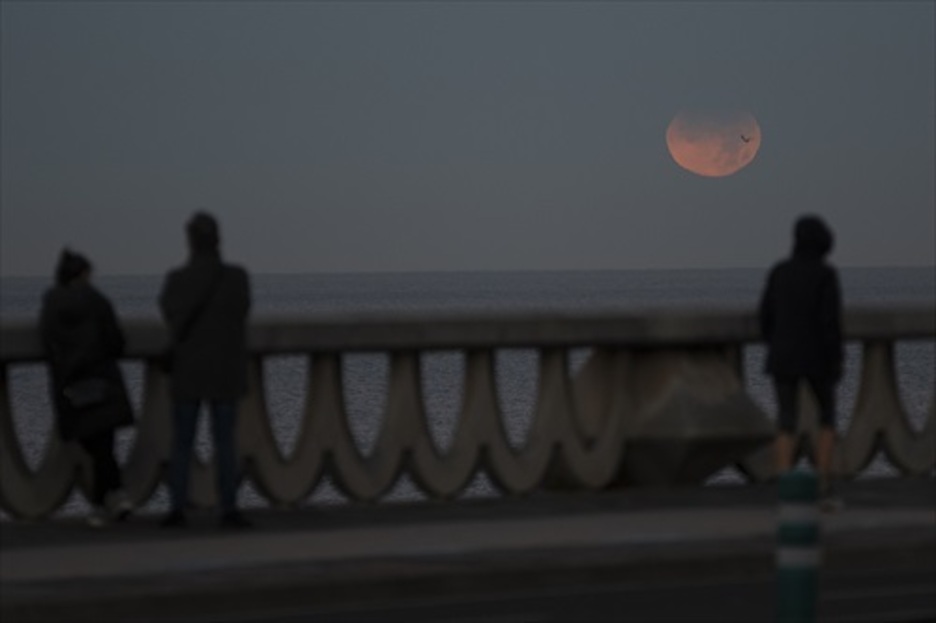 Personas observan un tímido eclipse en A Coruña. (M. DYLAN / EUROPA PRESS)