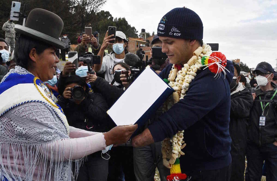 Théo Curin recibe el reconocimiento por parte de una concejal del municipio de Copacabana antes de nadar por el lago Titicaca. (Aizar RALDES/AFP)