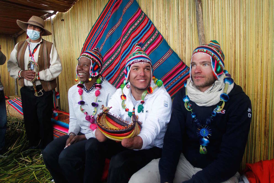 Theo Curin, Malia Metella y Matthieu Witvoet visten ropa local después de llegar a la isla de los Uros en Perú. (Carlos MAMANI/AFP)