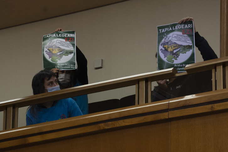 Miembros de la plataforma Araba Bizirik han llevado al Parlamento de Gasteiz carteles contra la ‘Ley Tapia‘. (Raul BOGAJO/FOKU)