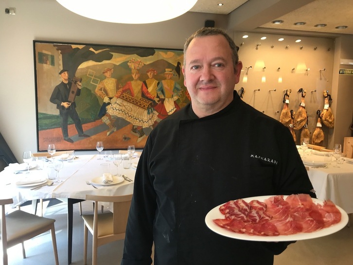 José Ignacio Jáuregui muestra un plato de jamón delante del histórico cuadro que da nombre a su empresa. 