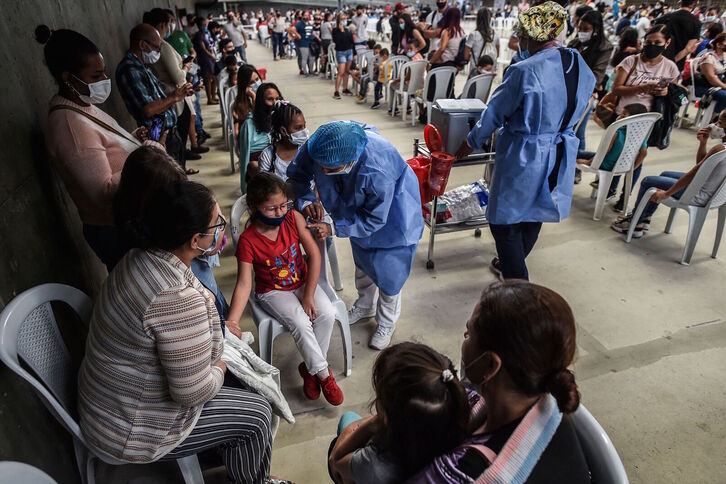 Niñas vacunándose en Colombia, una imagen que comenzará a verse en Euskal Herria este miércoles. (Joaquín SARMIENTO | AFP)