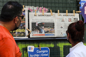 Viandantes observan las portadas de los diarios chileno en Santiado de Chile. (Javier TORRES /AFP)