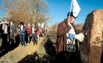 Victor Pachon, portavoz de Cade, acaricia la estela que recuerda la lucha contra la LGV durante la marcha entre Ahetze y Senpere. (Guillaume FAUVEAU)