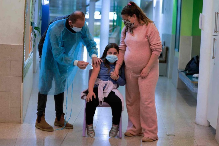 Una menor israelí recibe una dosis de la vacuna contra el covid. (Menahem KAHANA/AFP)