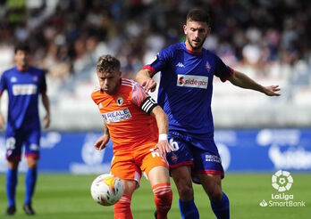 Markel Lozano junto a un rival durante el encuentro que enfrentó a Amorebieta y Burgos en la primera vuelta.