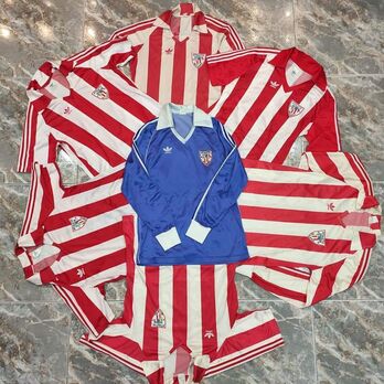 Athleticen kamisetak borobilean jarrita. 