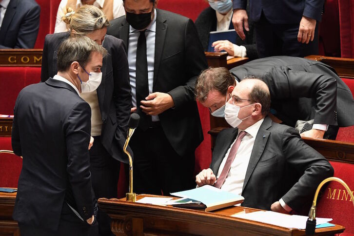 El ministro francés de Sanidad, Olivier Véran, habla durante un receso de la sesión, con el premier Jean Castex. 