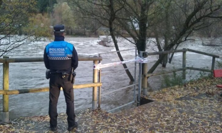 Un policía municipal de Iruñea vigila el cauce del río.