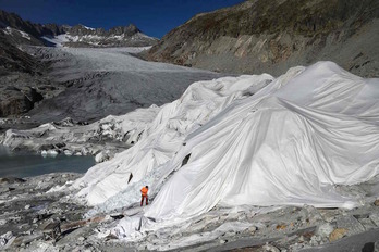 Un hombre cubre un glaciar con material aislante para ralentizar su desaparición, Suiza. 