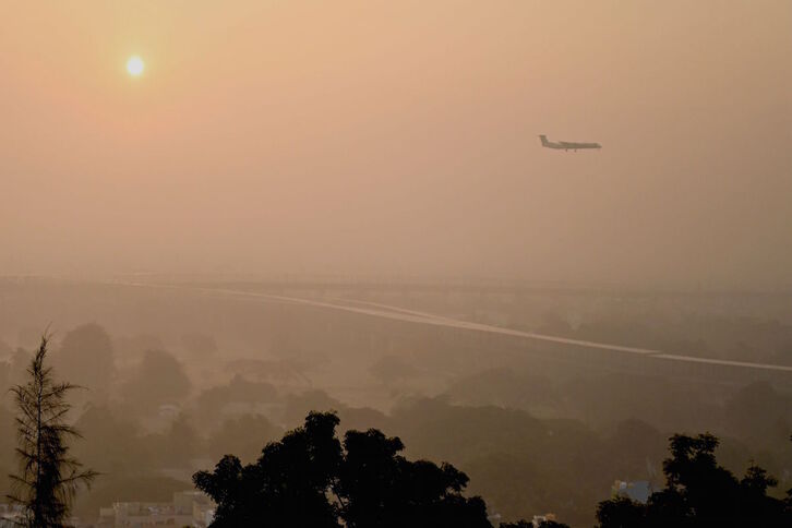 Un avión atraviesa el cielo contaminado. 