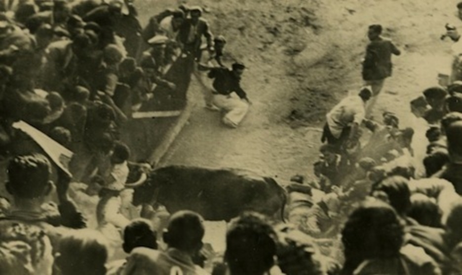 Un toro embiste a un corredor en el callejón en una carrera de 1924.