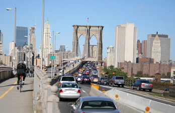 Hainbat auto eta txirrindulari bat New York-eko Brooklyn zubia zeharkatzen.