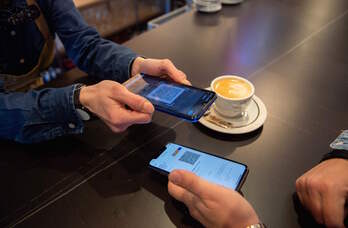 Un cliente muestra su pasaporte en un negocio de hostelería de Donostia. 