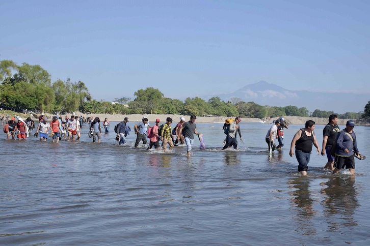 Migrantes centroamericanos cruzan un río. 
